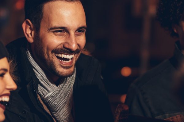 A group of friends in winter wrapped up warm and laughing