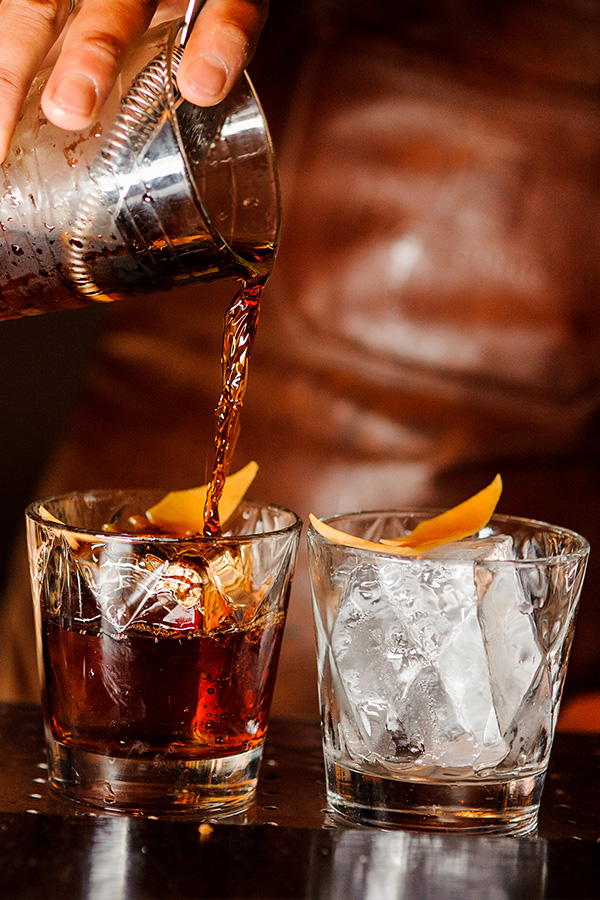 A drink being poured by a barman