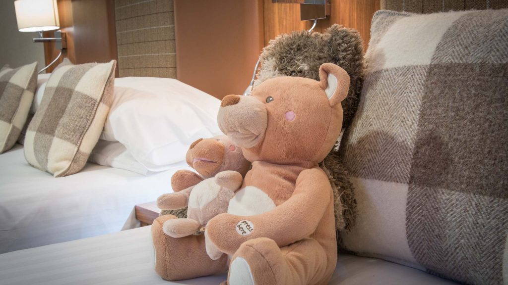 Teddies on a bed in a Family Room in Mackays Hotel in WIck