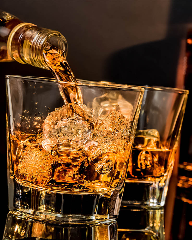 A glass of whisky being poured