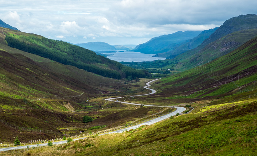 A section of the NC500 at Glen Docherty with a view of the road winding towards Loch Maree