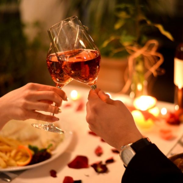 A couple toasting wine over a romantic dinner for two