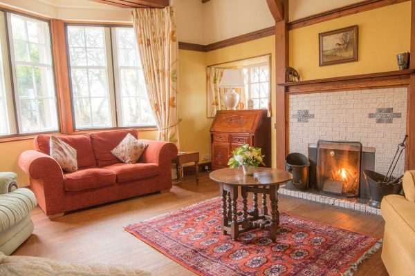 A cosy sitting room with a roaring fire at Langhills a self catering propert belonging to Mackays Hotel