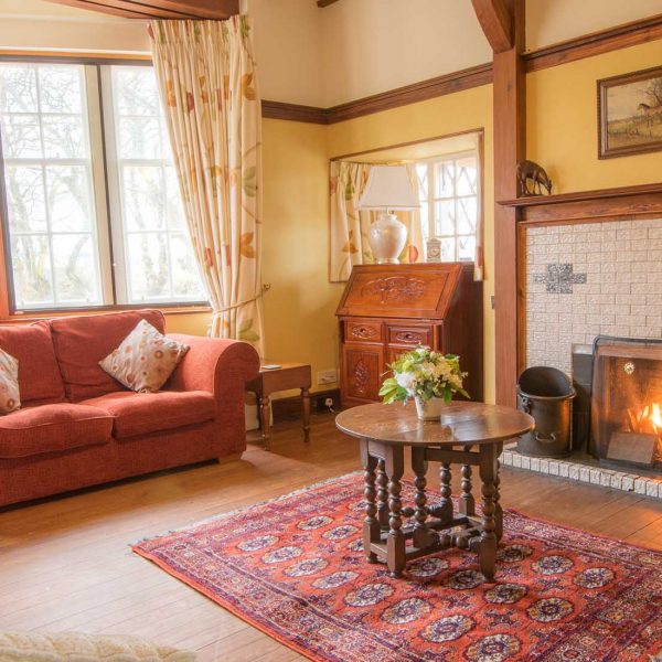 A cosy sitting room with a roaring fire at Langhills a self catering propert belonging to Mackays Hotel