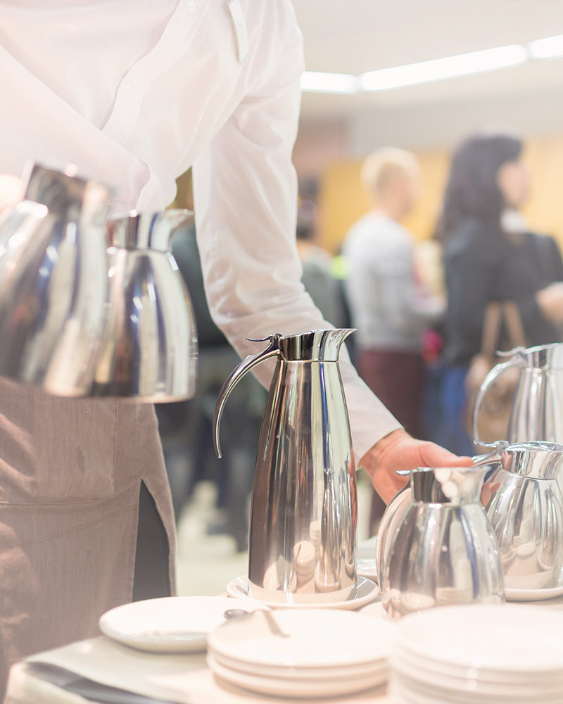 A waitress pouring teas and coffees at a corporate event