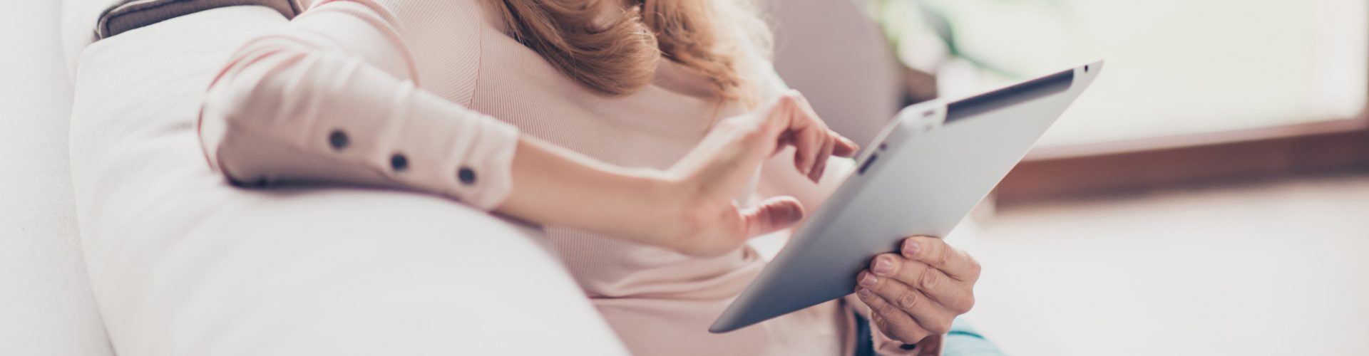 Woman using a tablet to book online