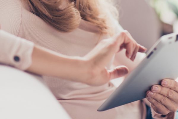 Woman using a tablet to book online