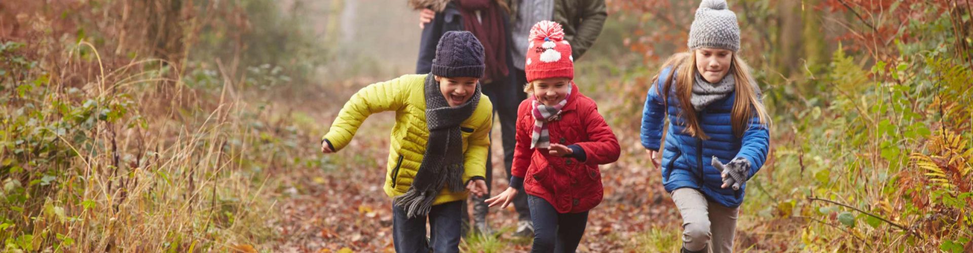 A family enjoys a winter walk with autumn leaves on a forrest path
