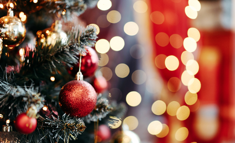 Close up of Christmas Tree with lights in background