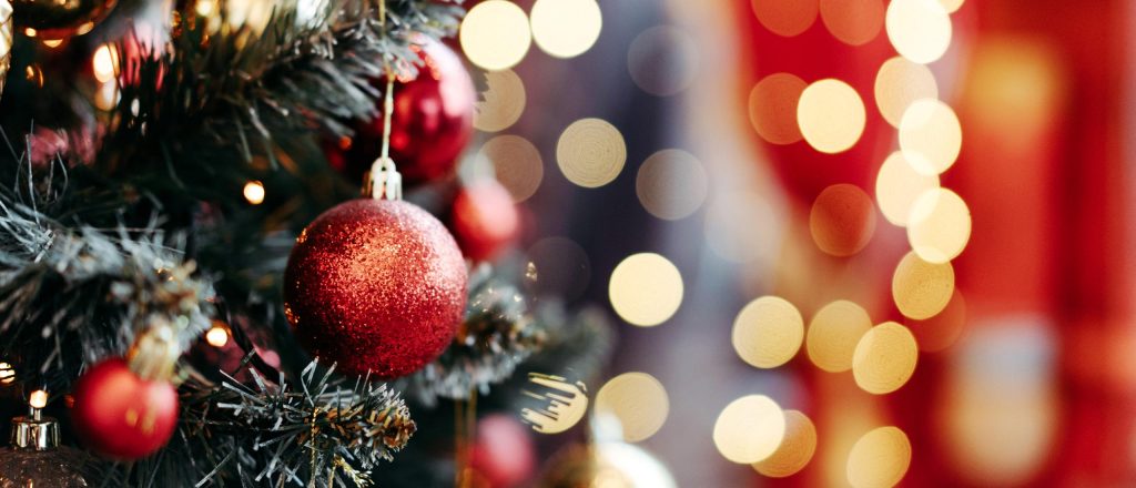 Close up of Christmas Tree with lights in background