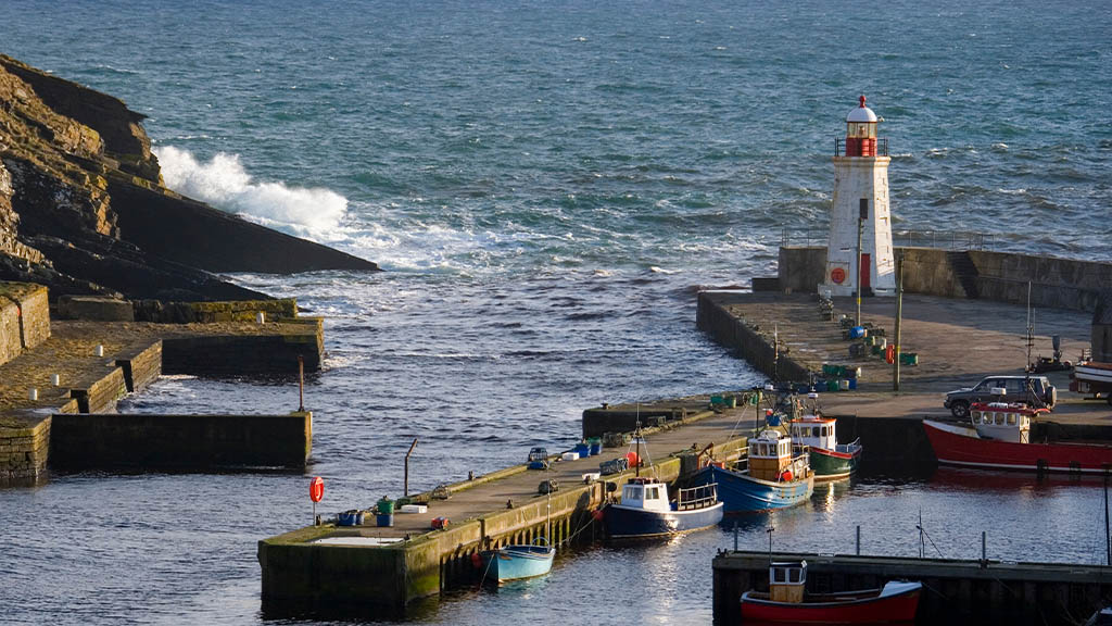 Lybster Harbour with waves crashing near the lighthouse