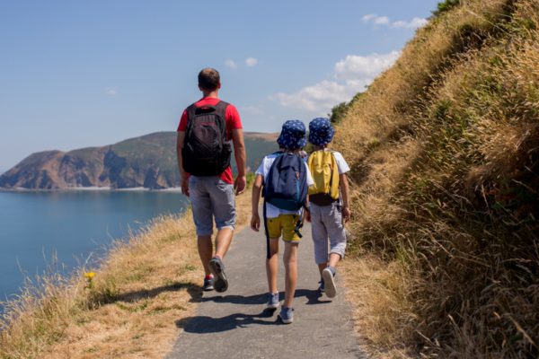 A family walk the cliffs together on a summers day