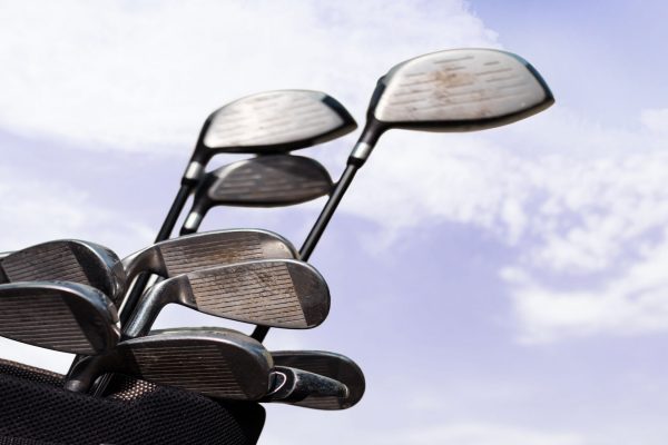 Bag of golf clubs against a blue sky