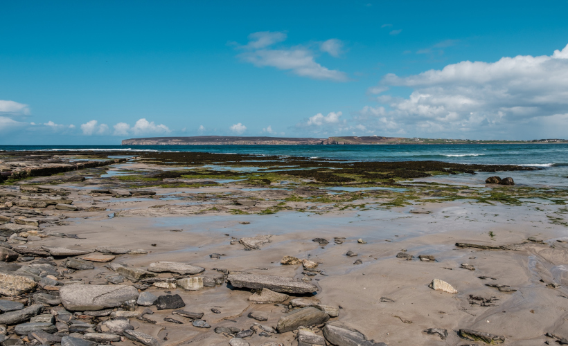 Rocks and small streams of water cross the beach at Dunnet in Caithness