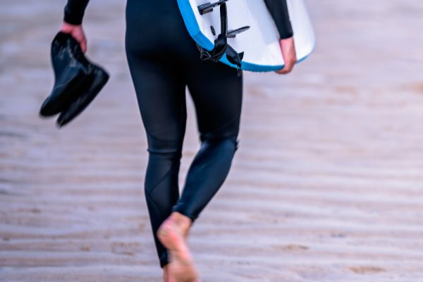 Surfer walking along the beach with board