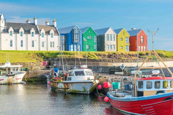 The colorful buildings of John O'Groats on a sunny afternoon