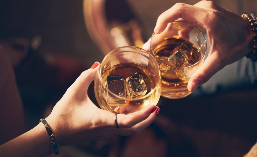Close up of couple toasting with whisky