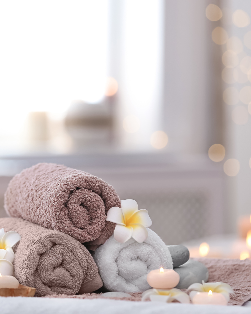 Rolled towels, flowers and candles at a spa
