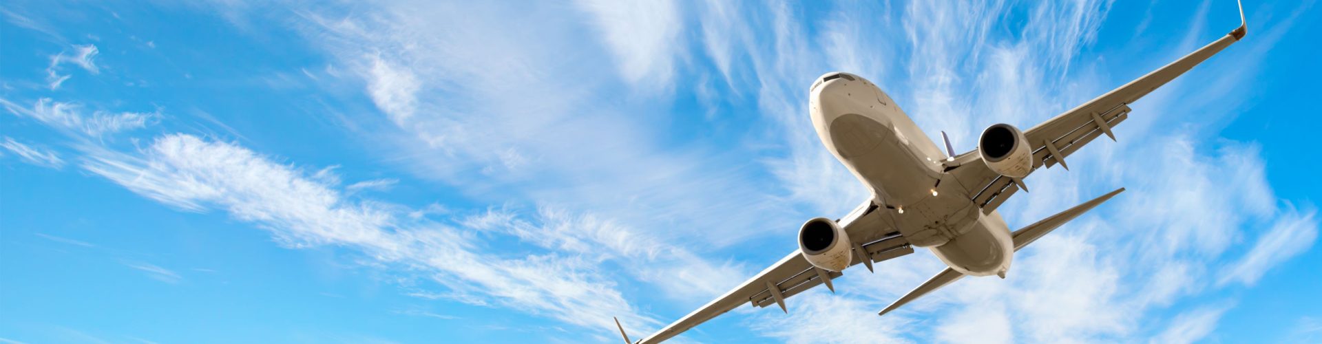 Passenger jet flying across blue sky