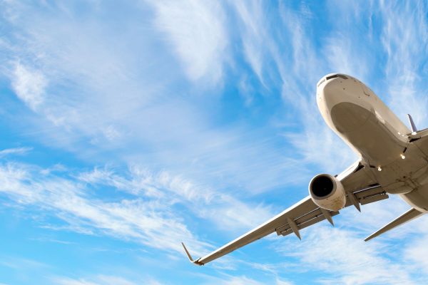 Passenger jet flying across blue sky