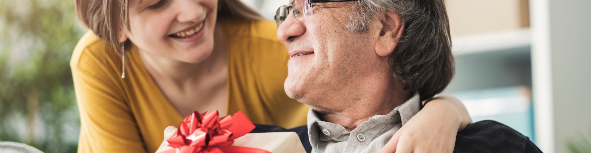 Woman giving her Dad a gift on Father's Day