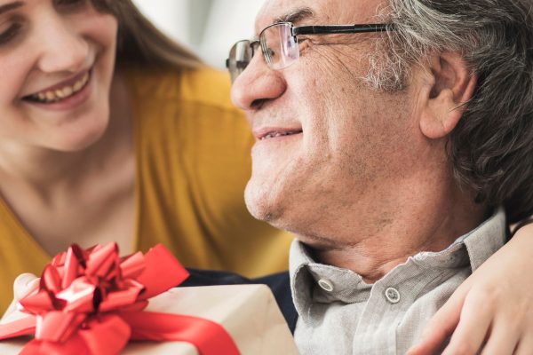 Woman giving her Dad a gift on Father's Day