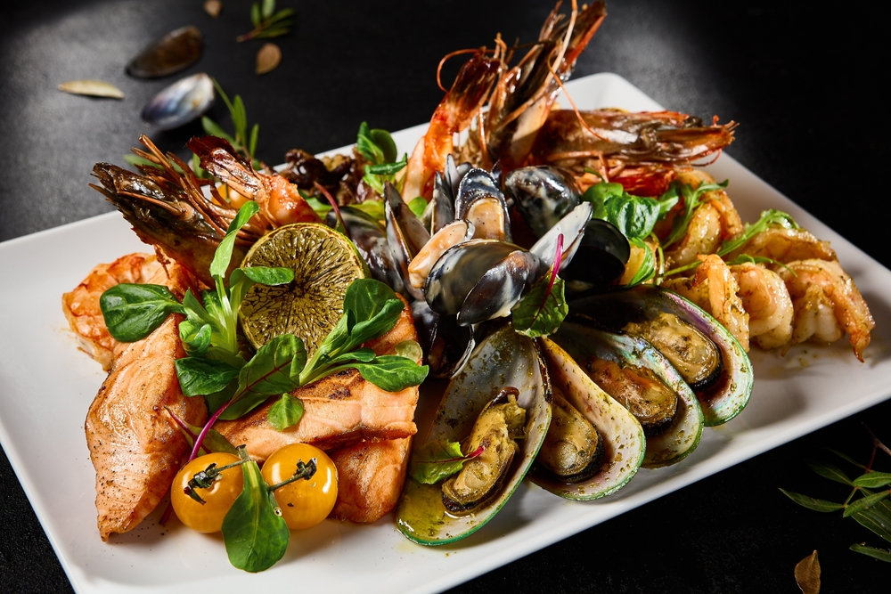 Gourmet Assorted Seafood Platter With Mussels, Salmon, Shrimp, and Octopus on Elegant Tableware.